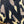 Close-up of a black embroidered letter 'N' patch applied to a beige, brown, and black camouflage patterned fabric.