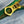 Close-up of a gold zipper pull on green fabric with a blue denim background