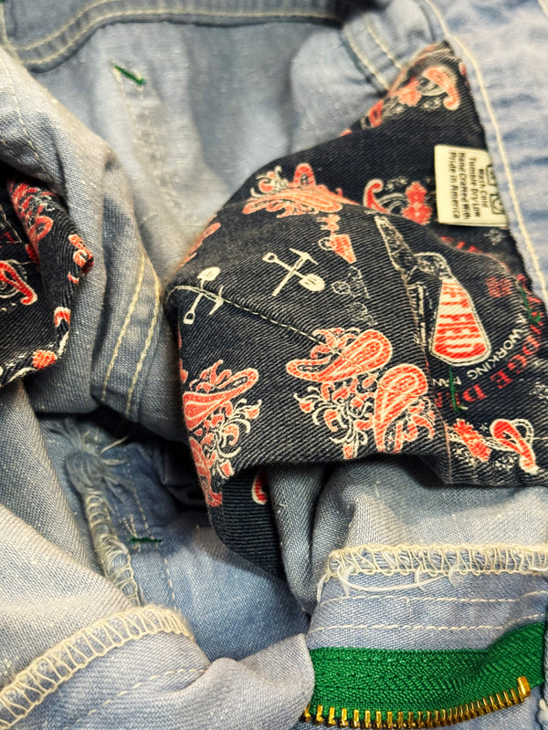 Close-up of a denim jacket with paisley pattern and brand label.