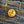 Close-up of a gold button with a design on a textured fabric background