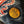 Close-up of a gold coin with '1998' on denim fabric with embroidered lettering.