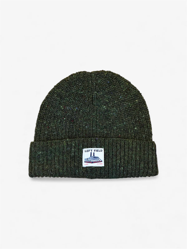 Green knit beanie with a label on a light gray background