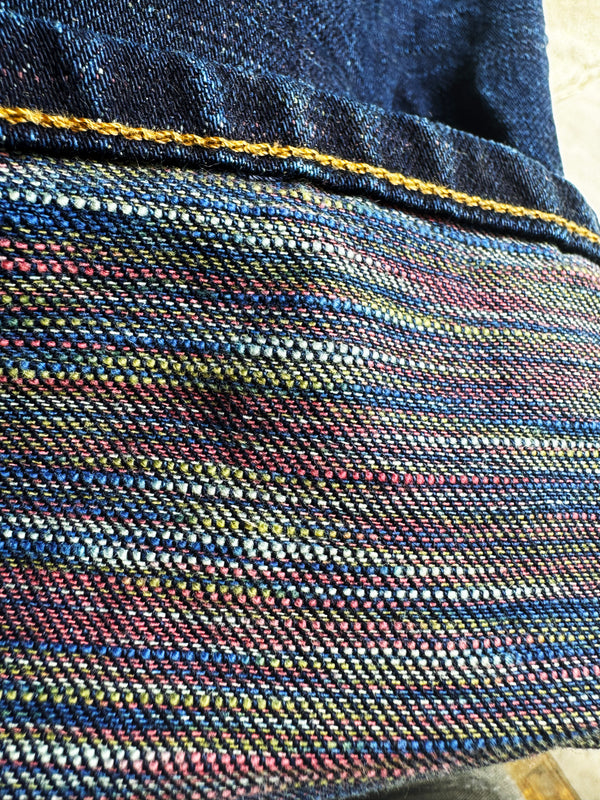 Close-up of woven fabric with multicolor pattern and blue border