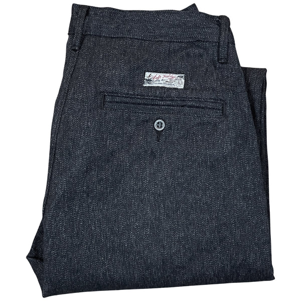 Folded pair of dark gray chinos with visible brand tag on the waistband