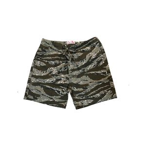 A pair of tiger stripe camouflage shorts in olive green, brown, and black, laid flat against a white background.