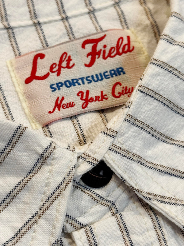 Close-up of a 'Left Field Sportswear New York City' label on a plaid fabric background.