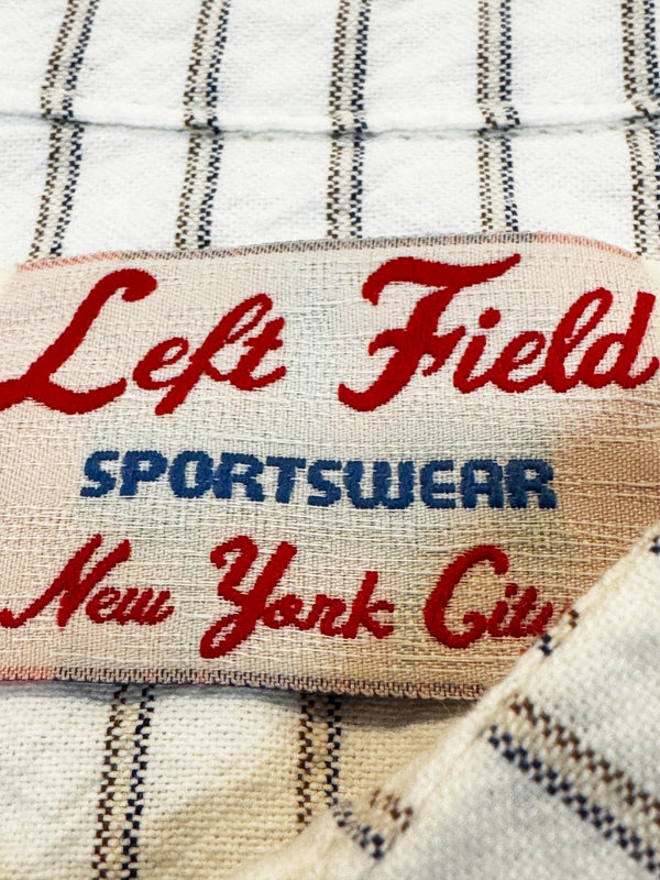 Label with 'Left Field Sportswear New York City' text on a striped fabric background
