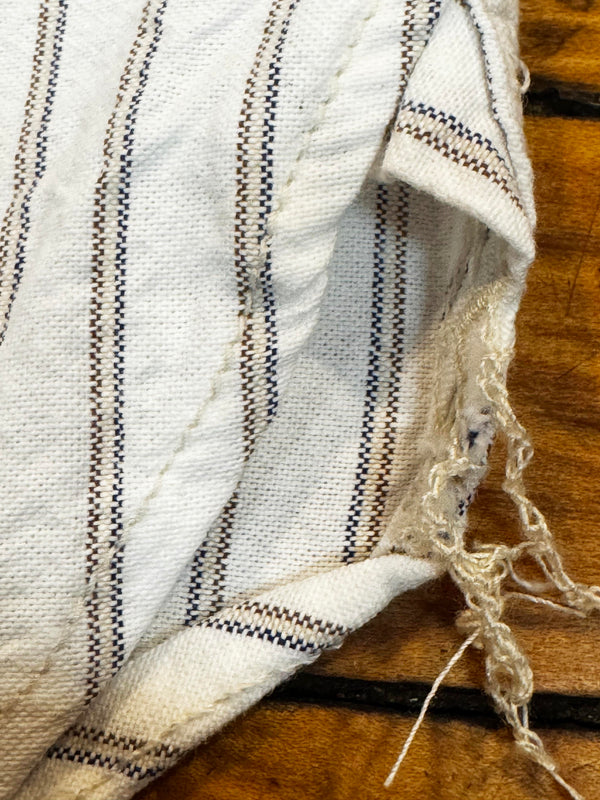 Close-up of a white fabric with black stripes on a wooden surface