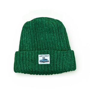 Green knit beanie with a label on a white background