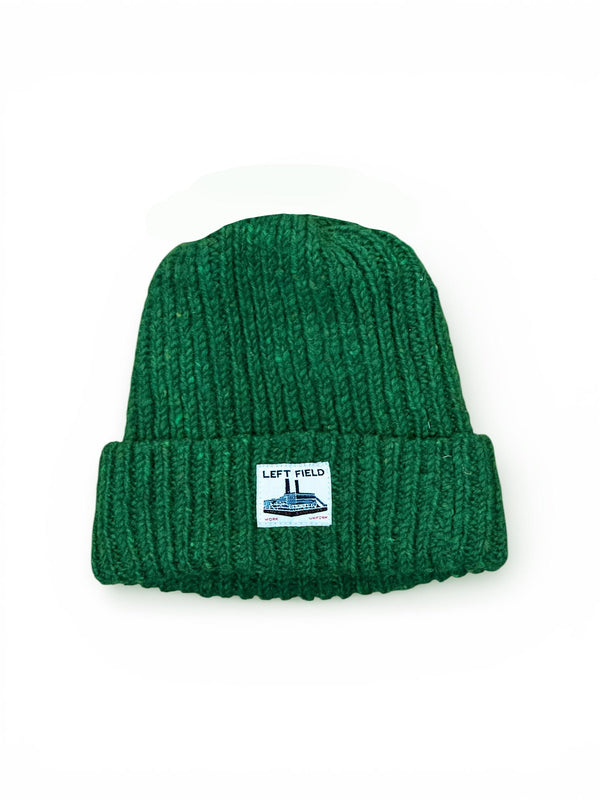 Green knit beanie with a label on a white background