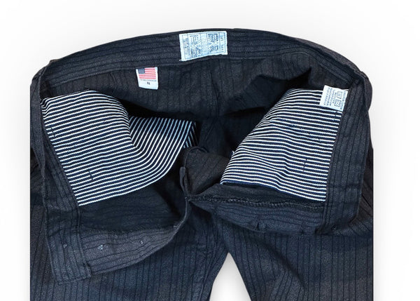Dark blue denim jeans with striped lining on a white background